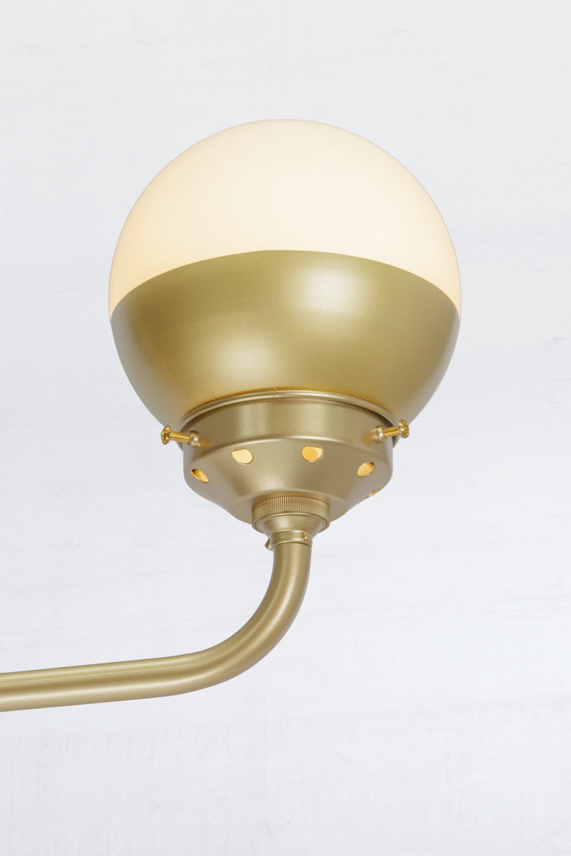 Close up of the gold/brass crown sphear shade and fixture.