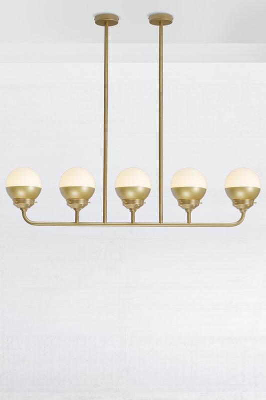 Crown sphear shades on a five lamp linear gold/brass chandelier. 