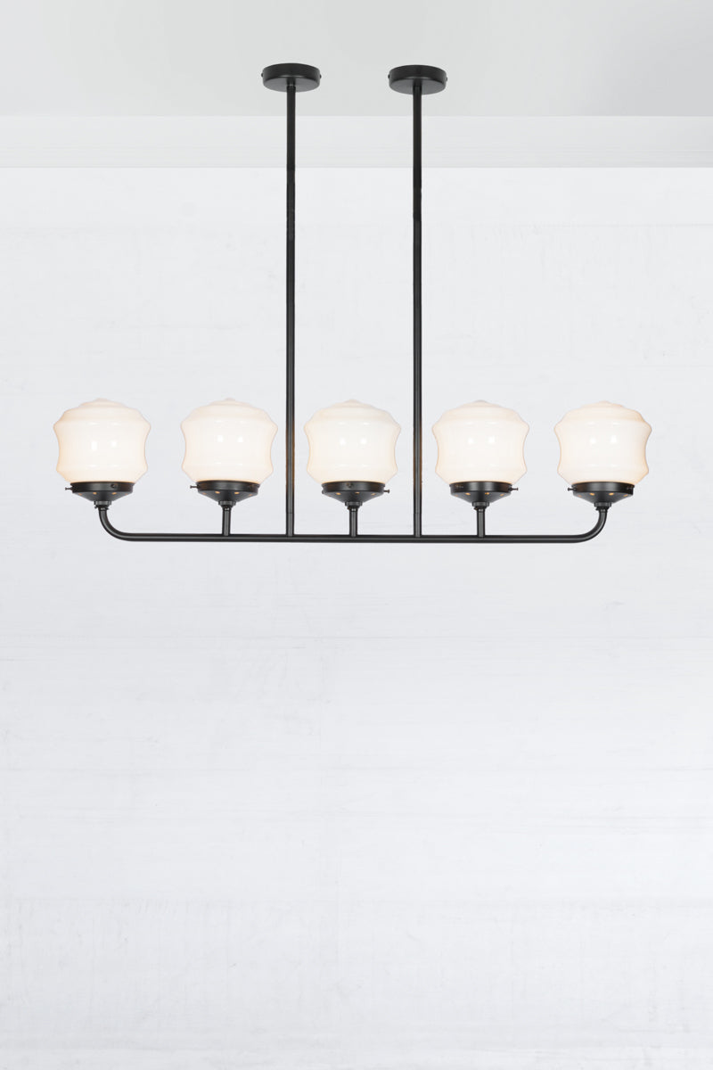 Five lamp black linear chandelier with schoolhouse style flinders opal shades. 