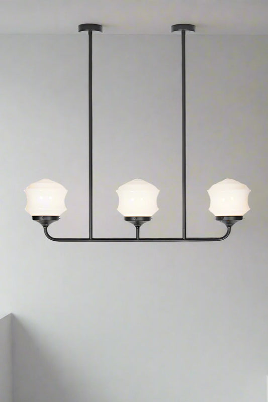 Triple lamp black linear chandelier with schoolhouse style flinders opal shades. 