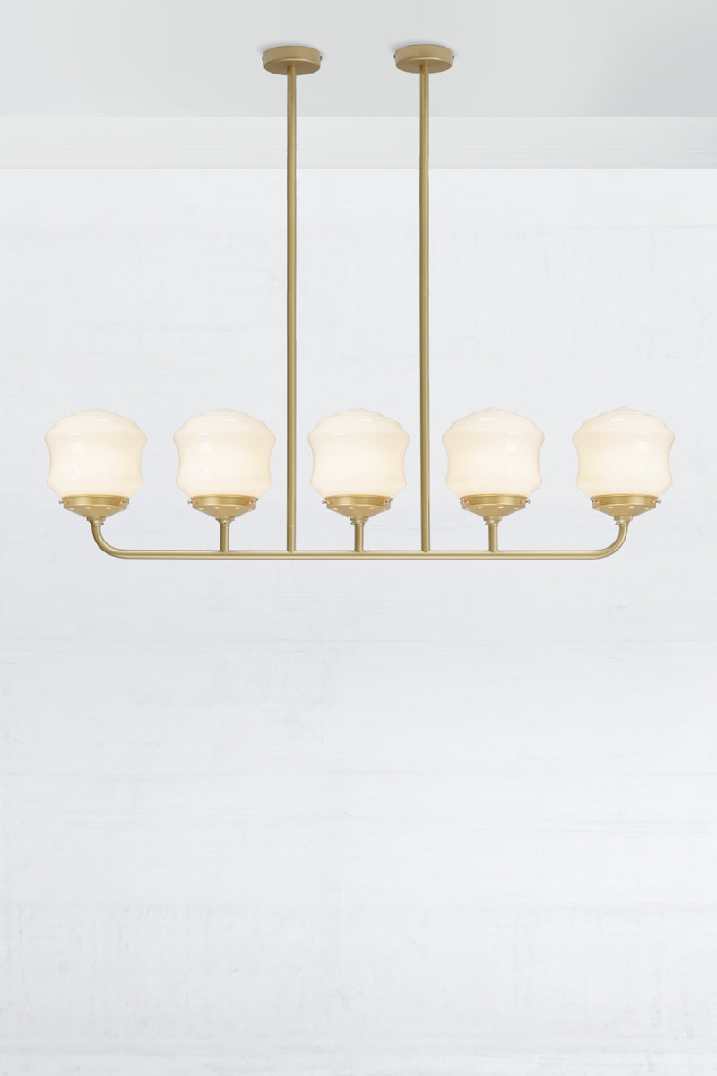 Five lamp gold/brass linear chandelier with schoolhouse style flinders opal shades. 