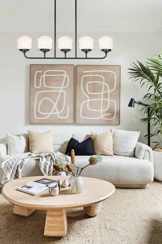 Five light black linear chandelier with opal flinders schoo house shades in a lounge room. 