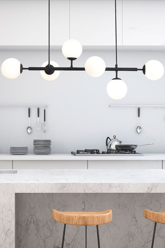 Black 6 light linear glass ball pendant light. in a kitchen.