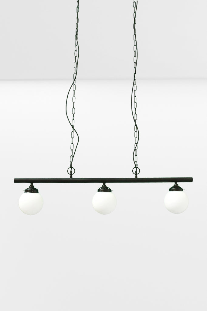 Small opall shades on the three light linear bar light with black chains. 