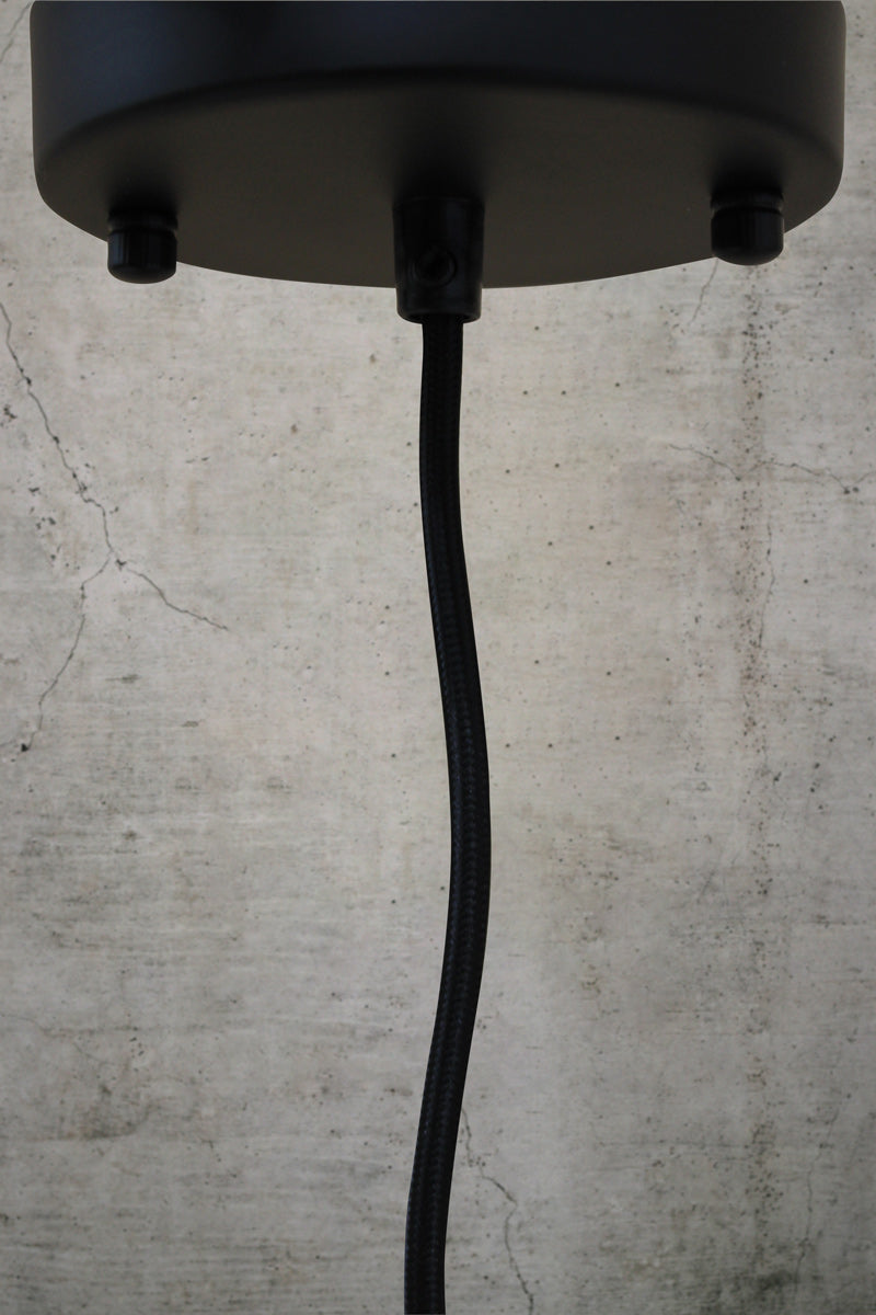 Black ceiling rose and cord on a concrete background