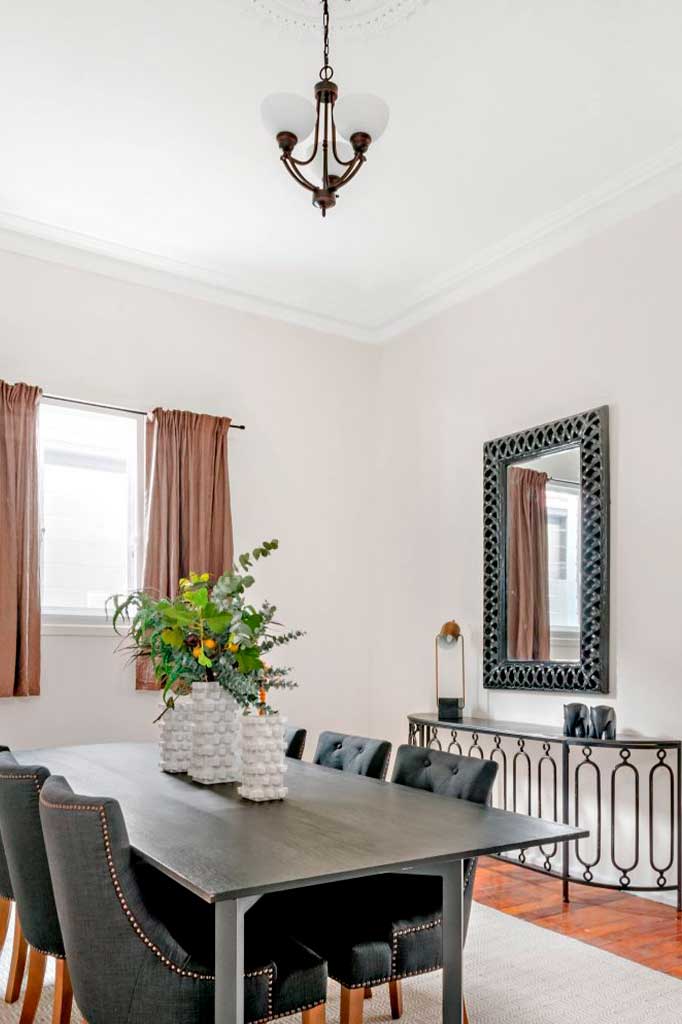 Small bronze chandelier with opal shades over dining table