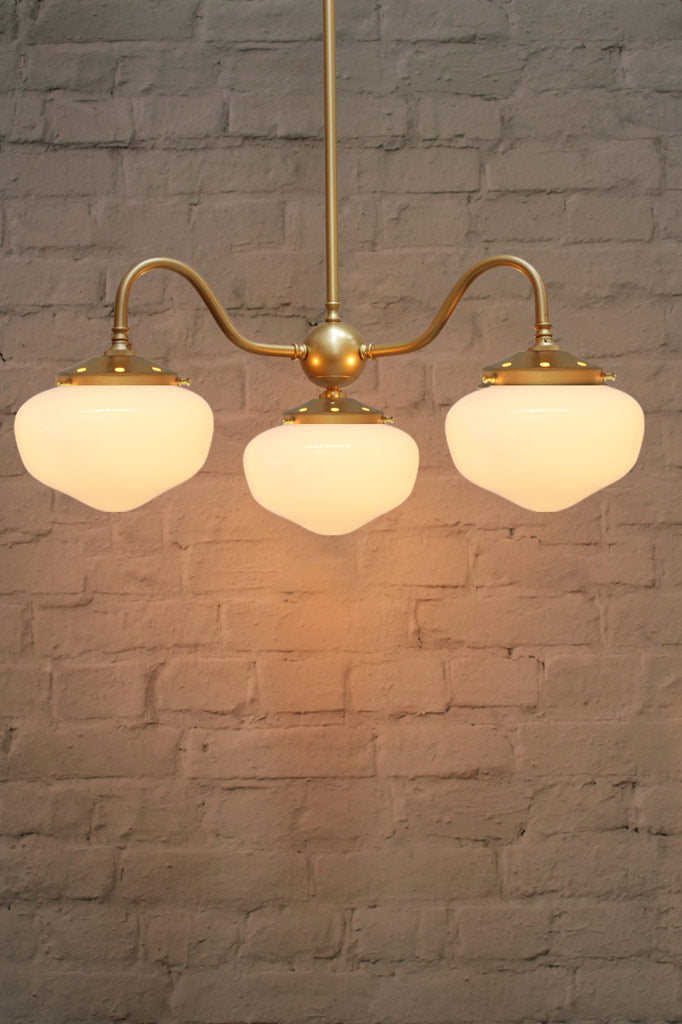 Gold/brass three are goosneck chandelier with opal schoolhouse style shades