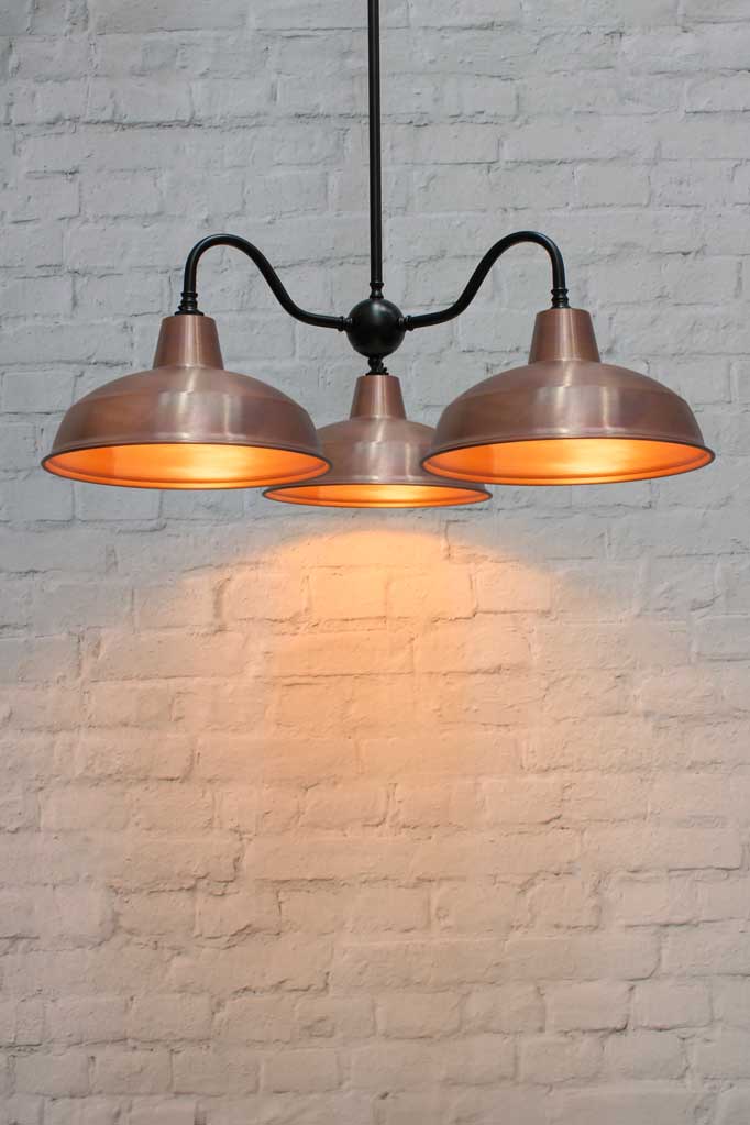 Industrial Gooseneck chandelier with a black fixture and copper shades.