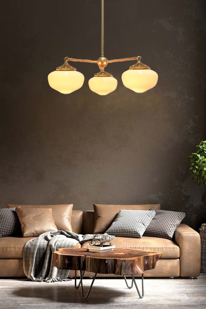 Gold/Brass 3 straight arm chandelier with opal washington shades in a lounge room.  