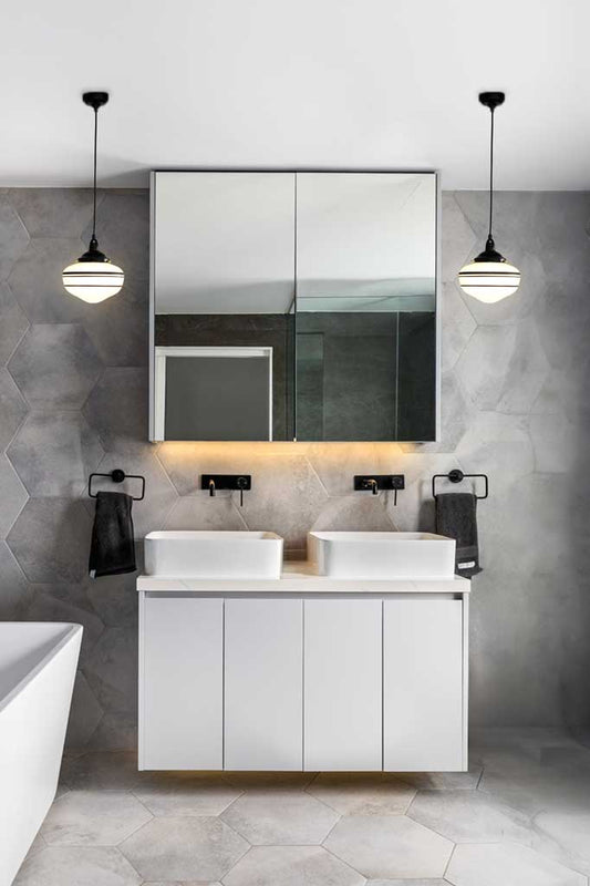  Two opal Washington shades with stripes and black hardware, hanging either side of a monochrome bathroom vanity.