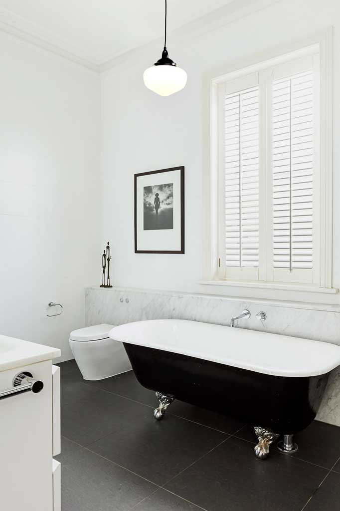 Opal Washington shade hanging on a black gallery and cord in a clack and white bathroom. 