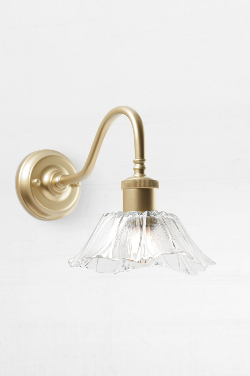 Sculptured glass shade on gold wall sconce