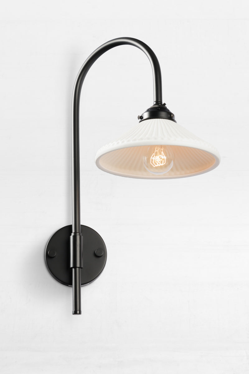 Shepard gooseneck wall light in black with a matt white ceramic shade. 