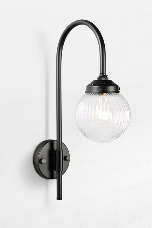 Shepard gooseneck wall light in black with a clear reeded glass ball shade. 