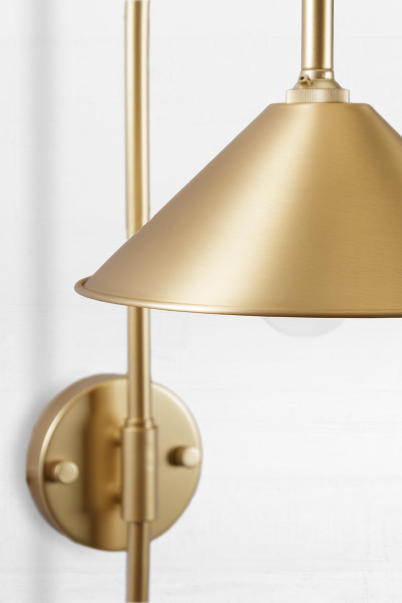 Close up of the Shepard gooseneck wall light in gold/brass with a solid brass cone shade. 