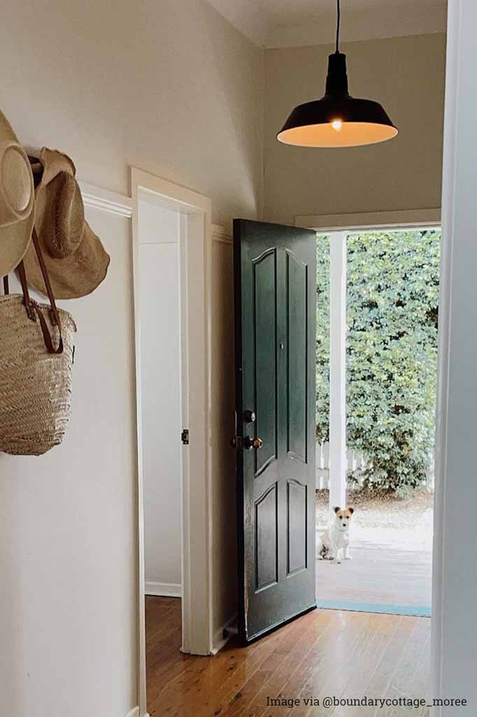 Black shade pendant light hanging in home entryway. 