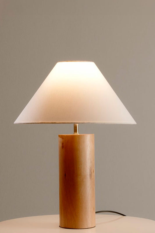 Table Lamp switched on, casting a soft glow through its white linen shade.