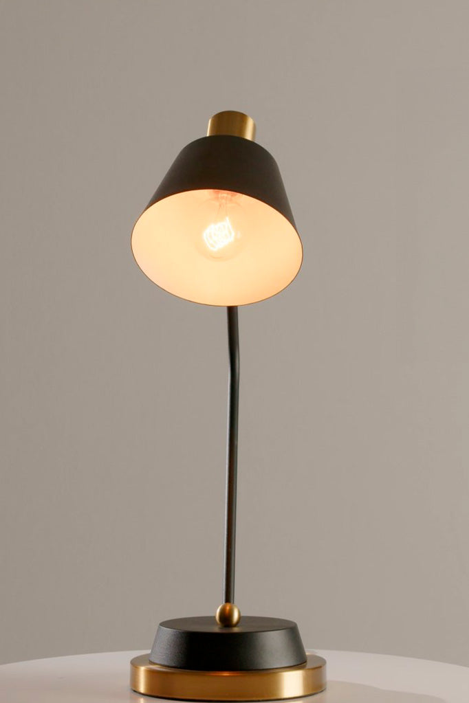 Front view of the Cine Table Lamp highlighting its matte black shade and gold accents.