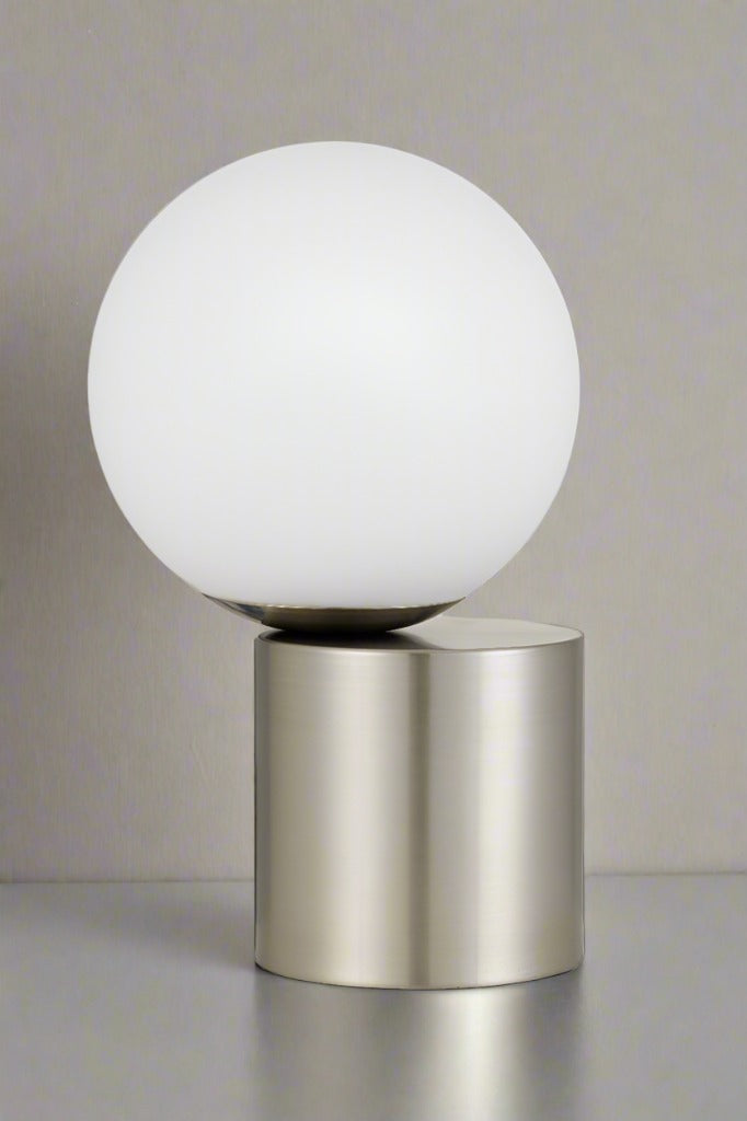 Off centred opal ball shade on a nickel cylindrical touch lamp base.