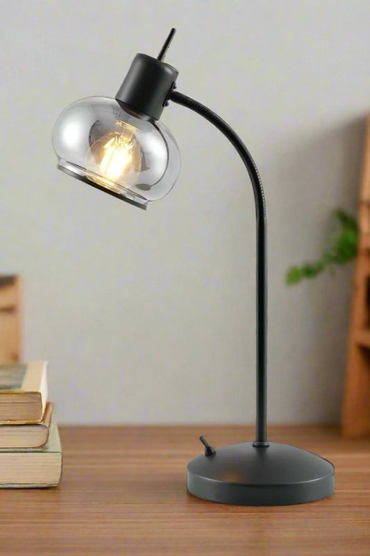 Manhattan table lamp in black on a timber table with a stack of books. 