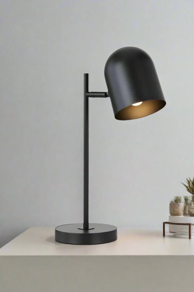 Black table lamp with adjustable head on a desk. 