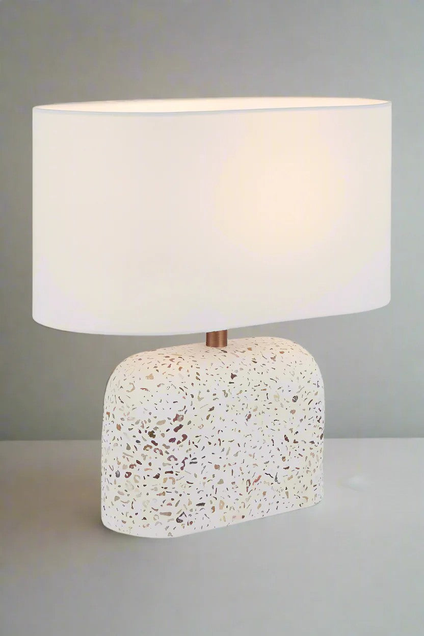 Elongated terrazzo lamp with ivory shade.