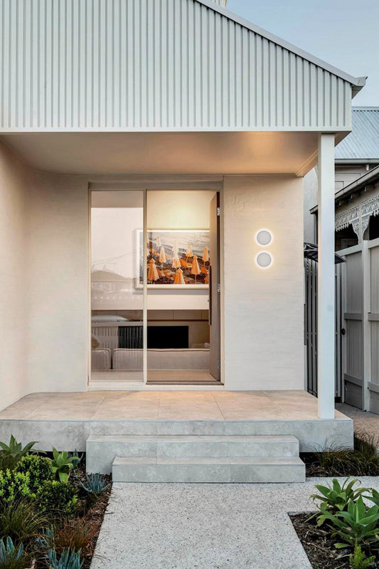 Two sandstone circular wall lights on a front entrance