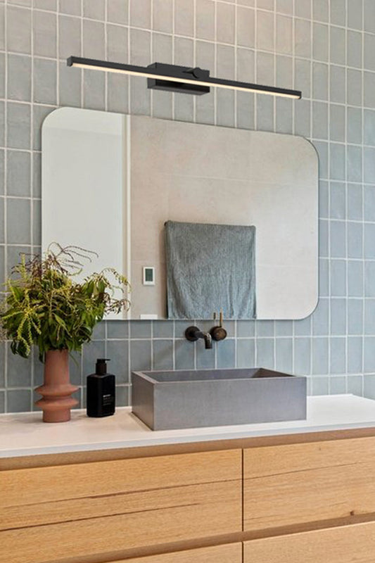 Large black linear vanity light in a fresh bathroom