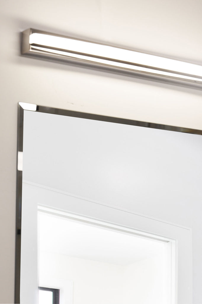 Small chrome vanity wall light above a mirror