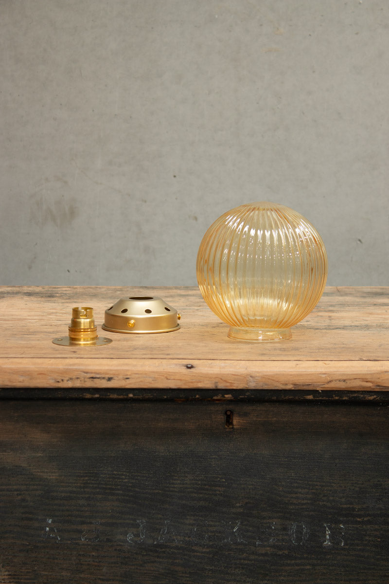 amber glass reeded shade wiht gold brass wall plate