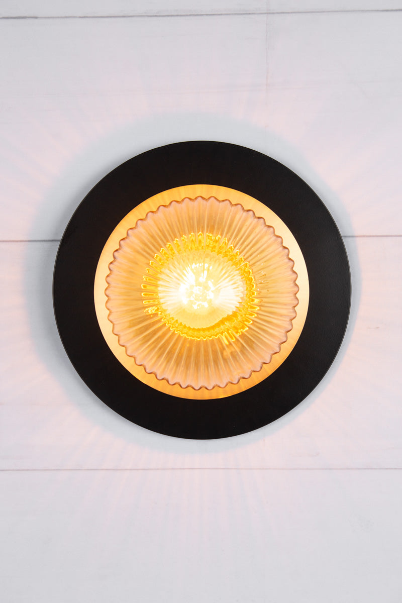  Small amber reeded glass ball shade n a small brass disc and large black disc.