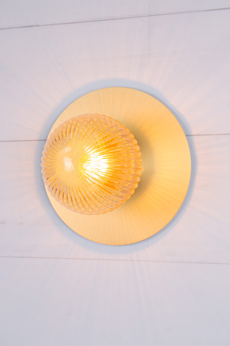 Small amber reeded glass ball shade n a large brass disc. 