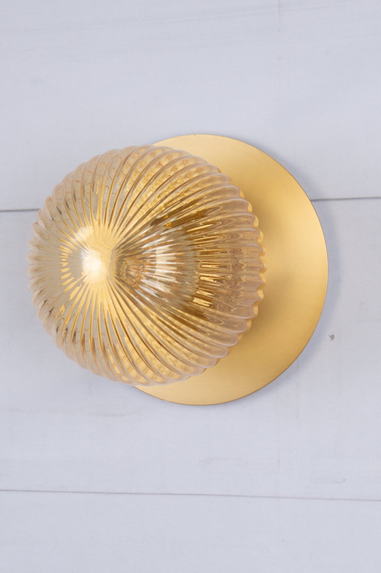 Small clear reeded glass ball shade paired with a brass disc. 