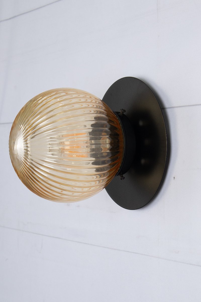 Small amber reeded glass ball shade n a small black brass disc. 