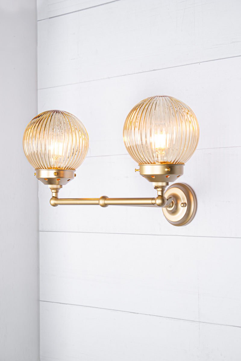 gold brass arm sconce with amber shades 