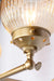 gold brass arm sconce with detailing of amber shade