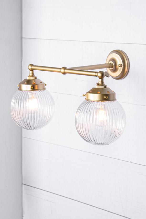 gold brass arm sconce with clear shade