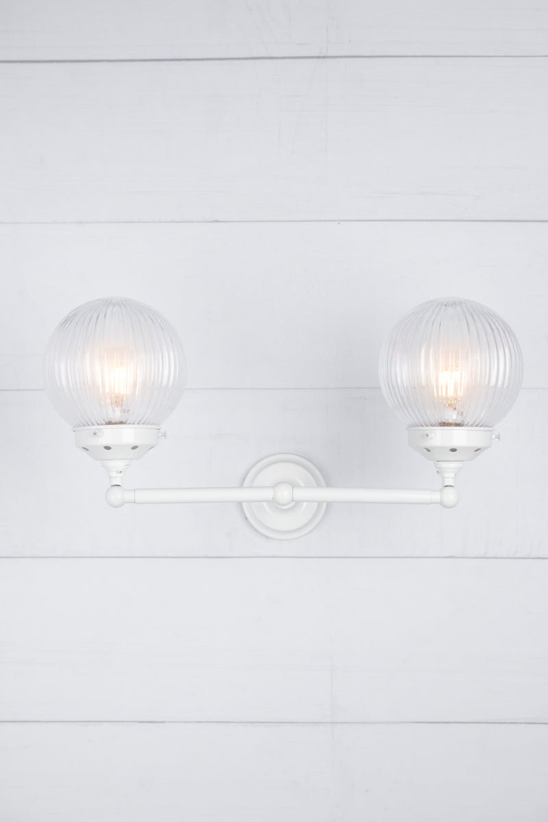 clear shades on white arm sconce