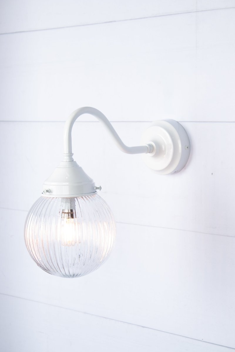 Exterior wall light with a white gooseneck arm and clear reeded shade, side view.