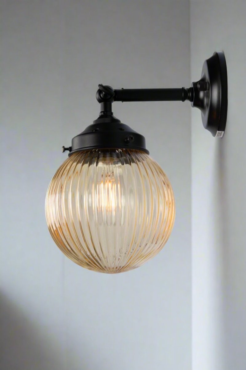 Amber glass reeded ball shade on a short black swivel straight arm.