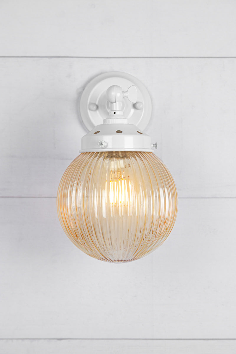 Amber glass reeded ball shade on a short white swivel straight arm.