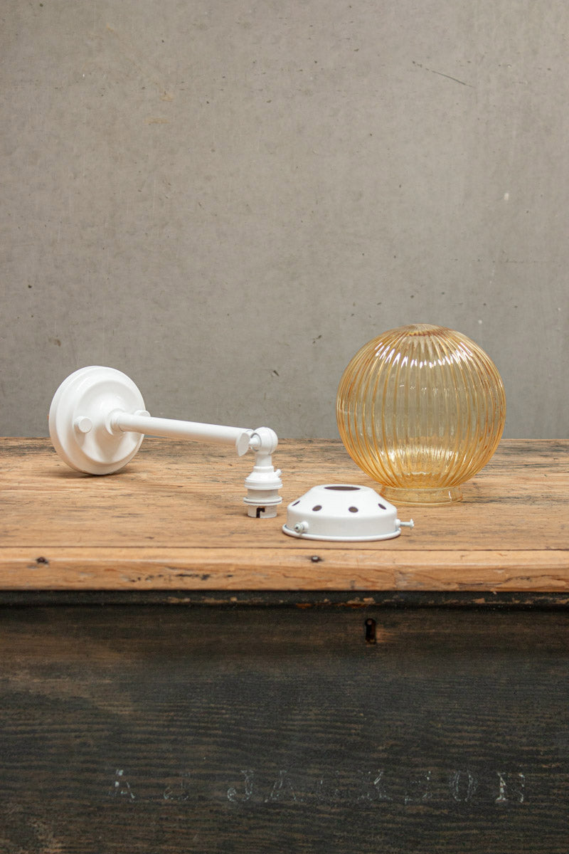 Disassembled Amber reeded glass ball light with white gallery and long straight arm. 