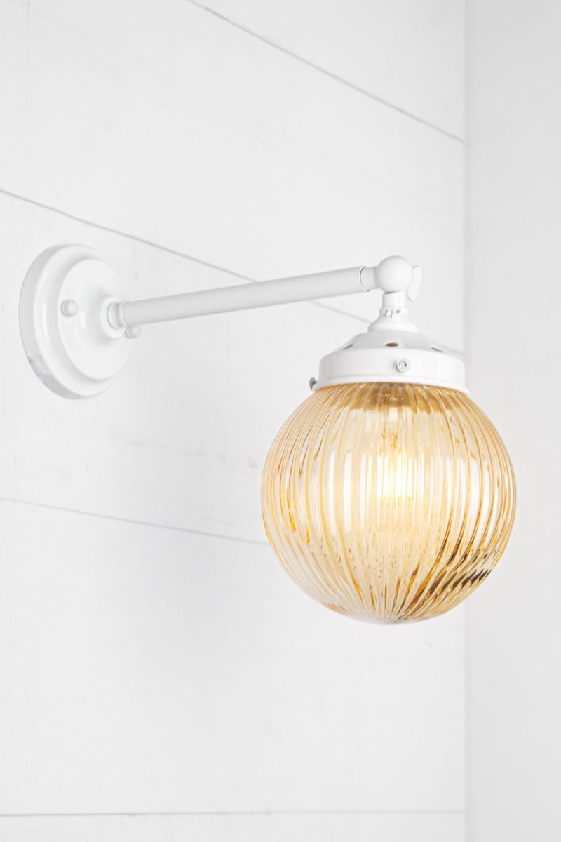 Amber glass reeded ball shade on a long white swivel straight arm.