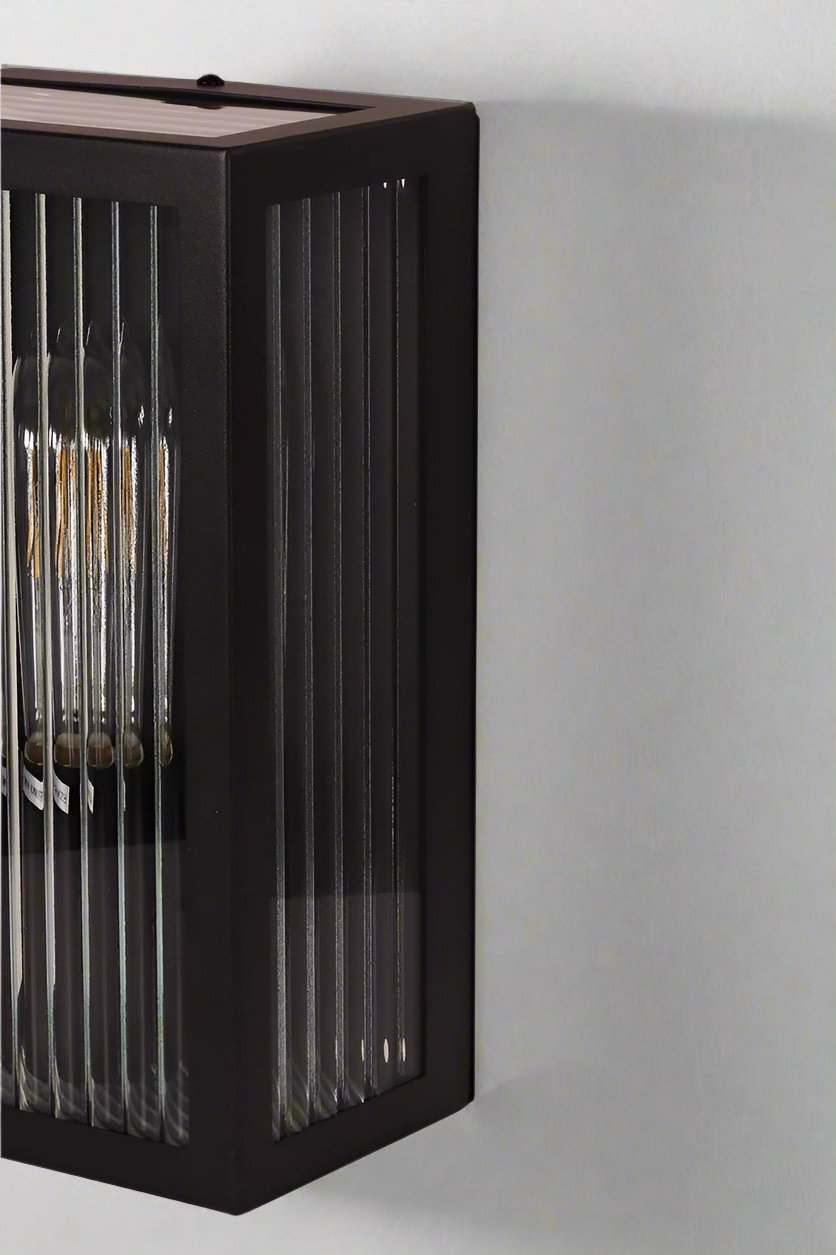 Close up of the reeded clase and black fram of the Finch wall light