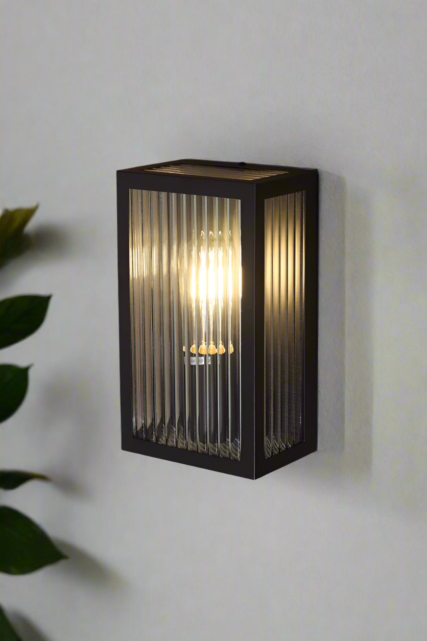 Corner view of the black framed reeded glass wall light