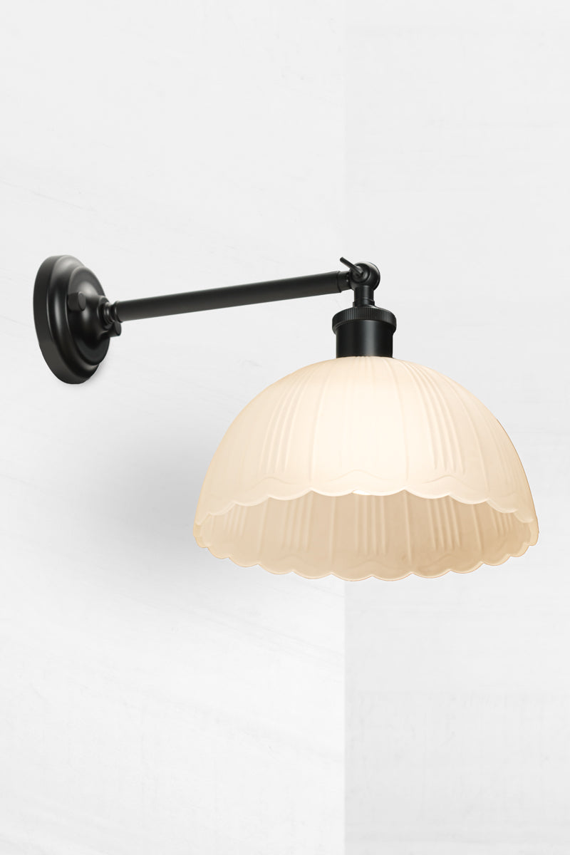 long black sconce with dome shade and scalloped edging