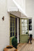 Aged brass up/down spotlights either side of green French doors. Image Via Homes to Love.