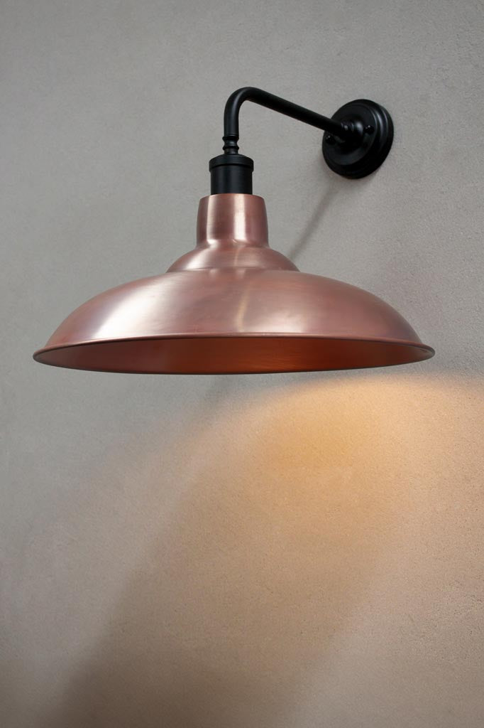 Black 90 degree wall sconce with a solid copper shade.