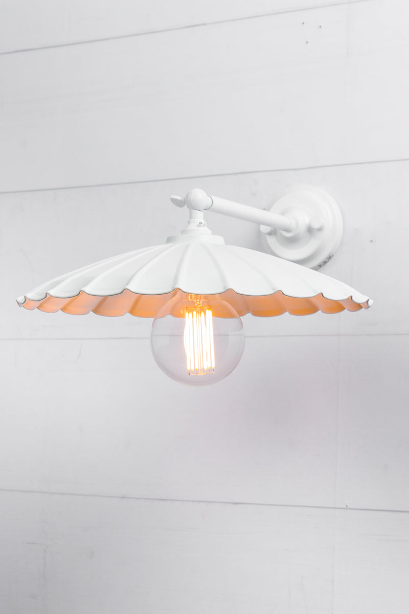 Large white umbrella shade on a white wall sconce. 