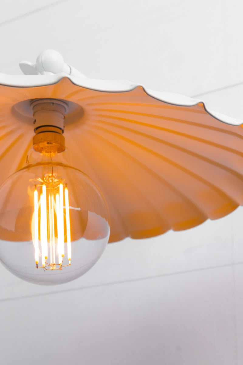 Close up of a white umbrella shade on a white wall sconce. 